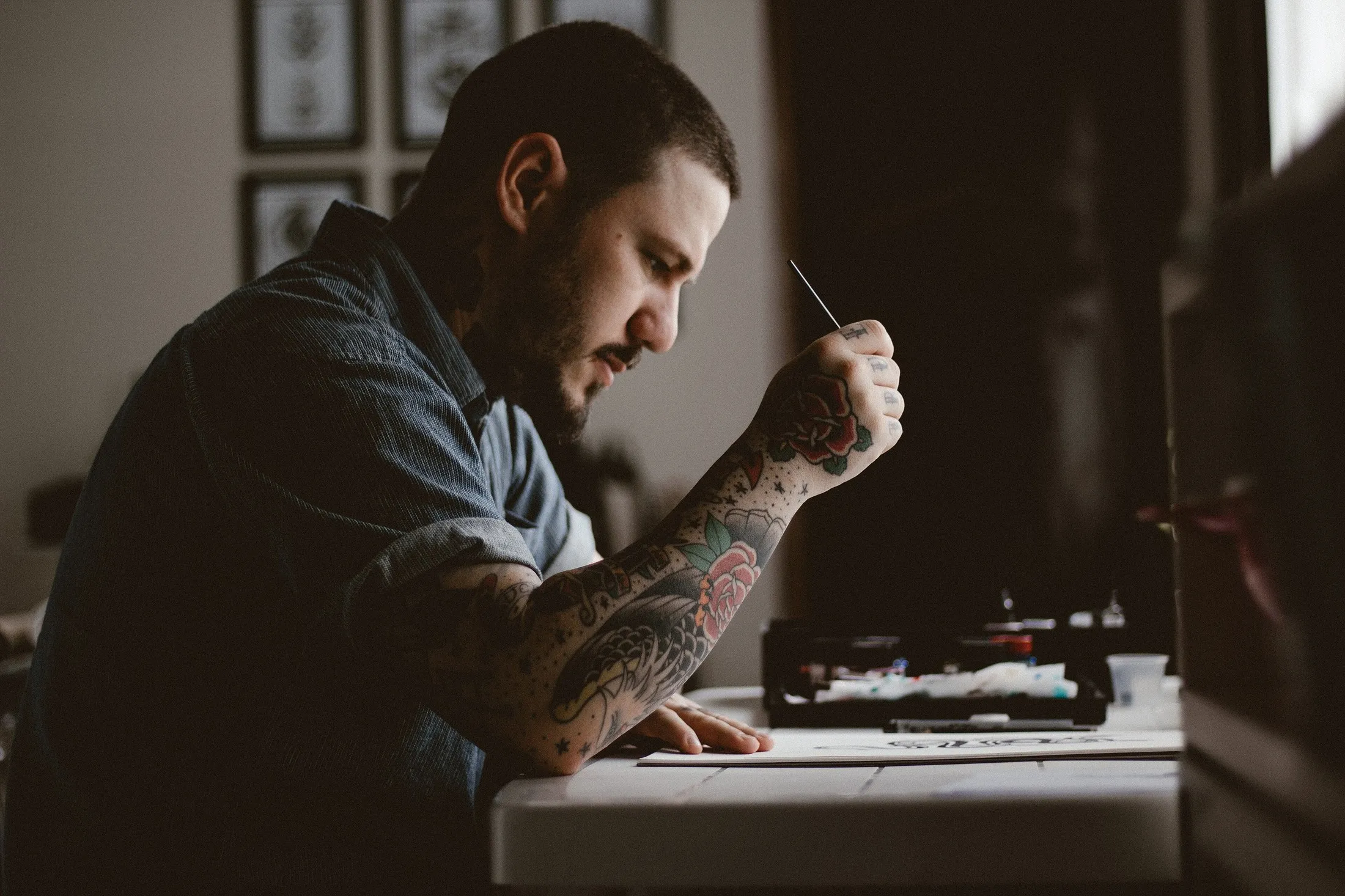 El tatuador preparando la máquina en el estudio (foto de muestra)